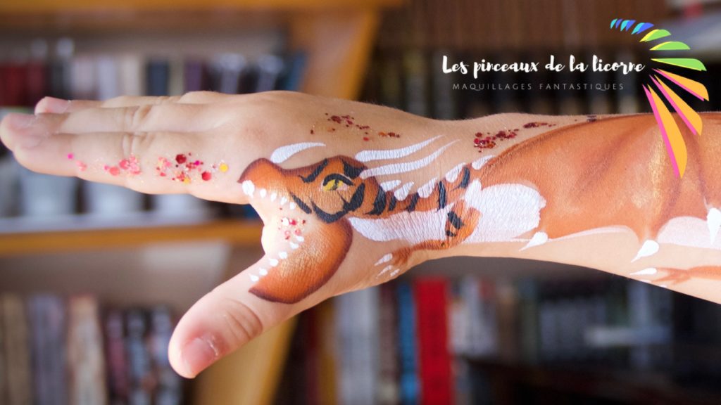 Un dragon peint sur une main d'enfant