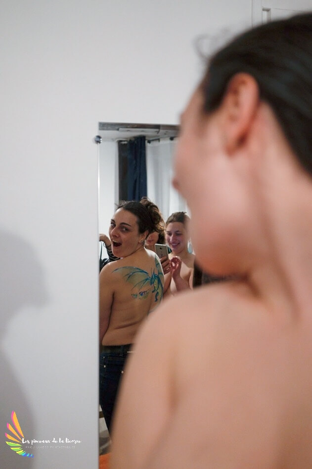 A young woman is amazed by her back Dragon bodypainting