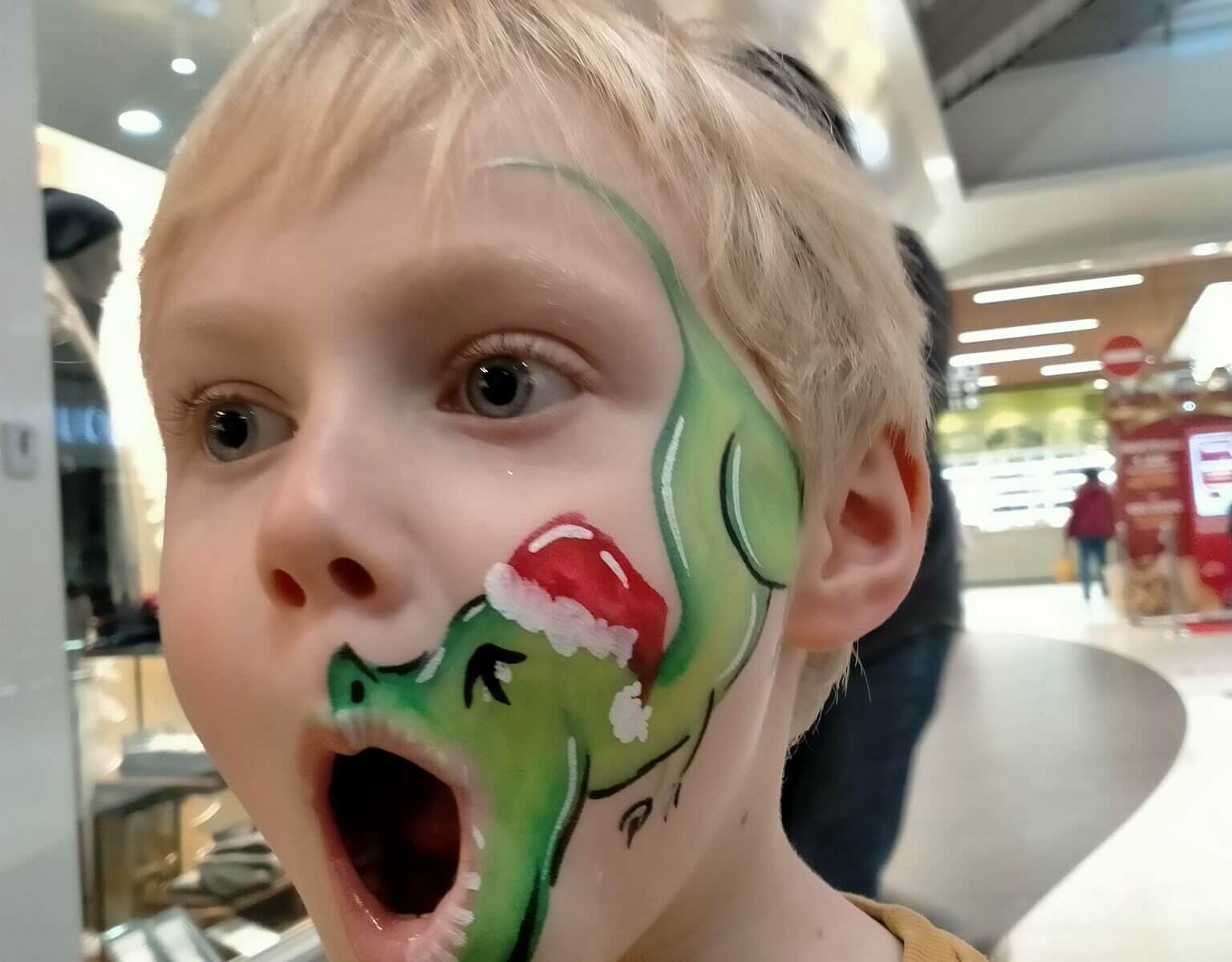 Enfant avec un maquillage de dinosaure de Noël